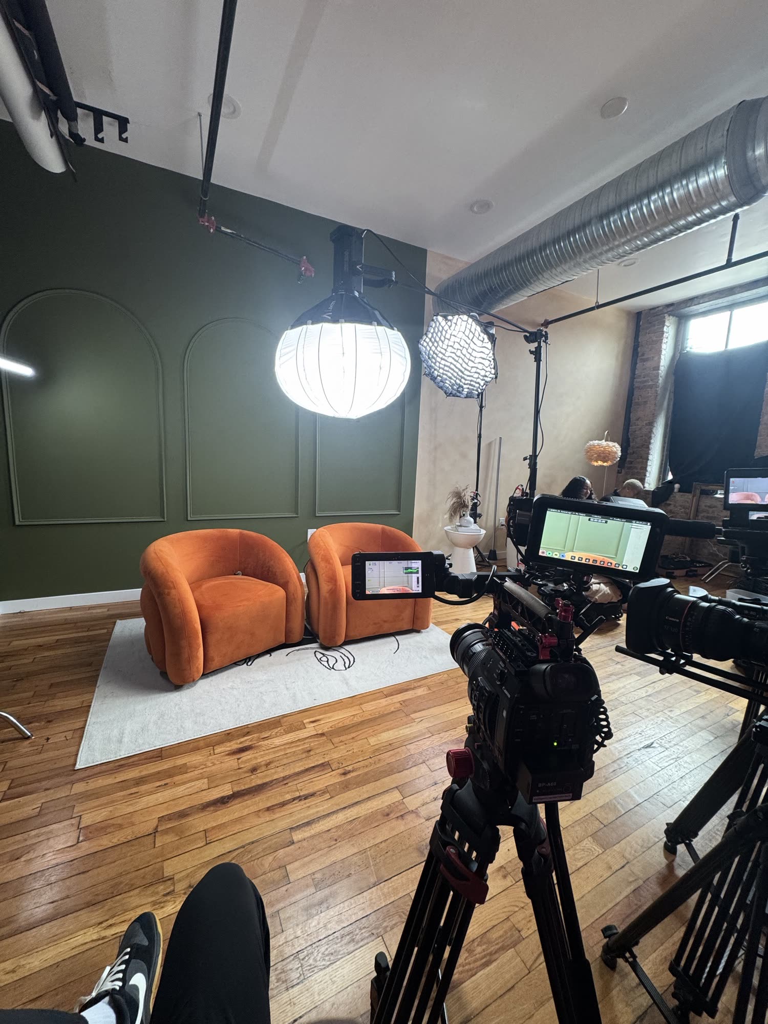 Podcast set with two chairs, lights, and cinema cameras