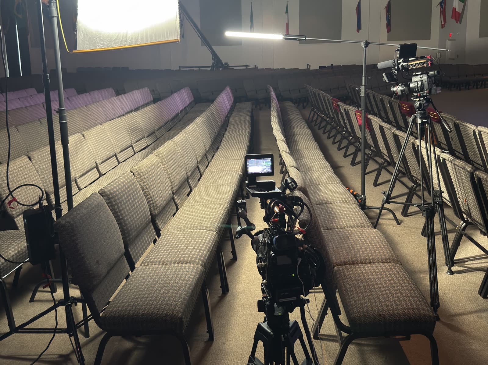 Broadcast camera set up in the aisle of a sanctuary